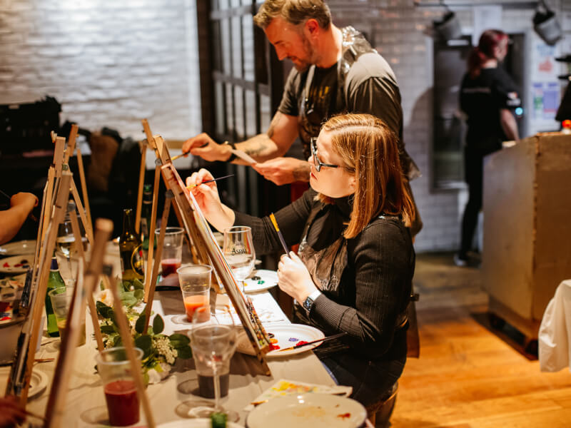 Woman immersed in her painting at a Perth paint and sip class