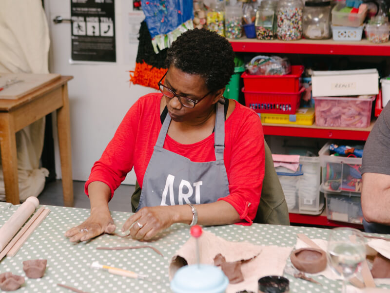 A woman handbuilds at a pottery workshop