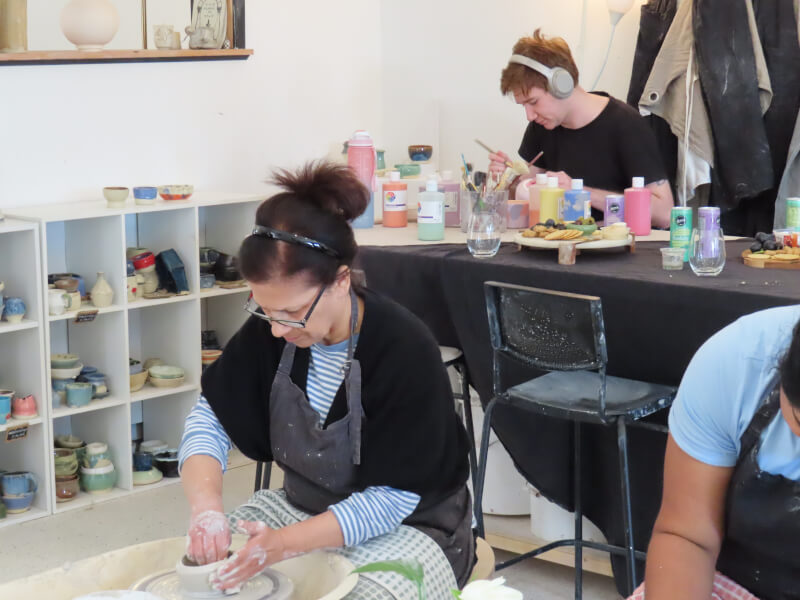 Woman on the wheel at a pottery class