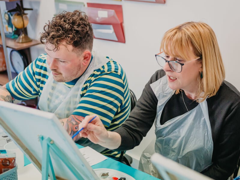 A mother at a painting class with her son