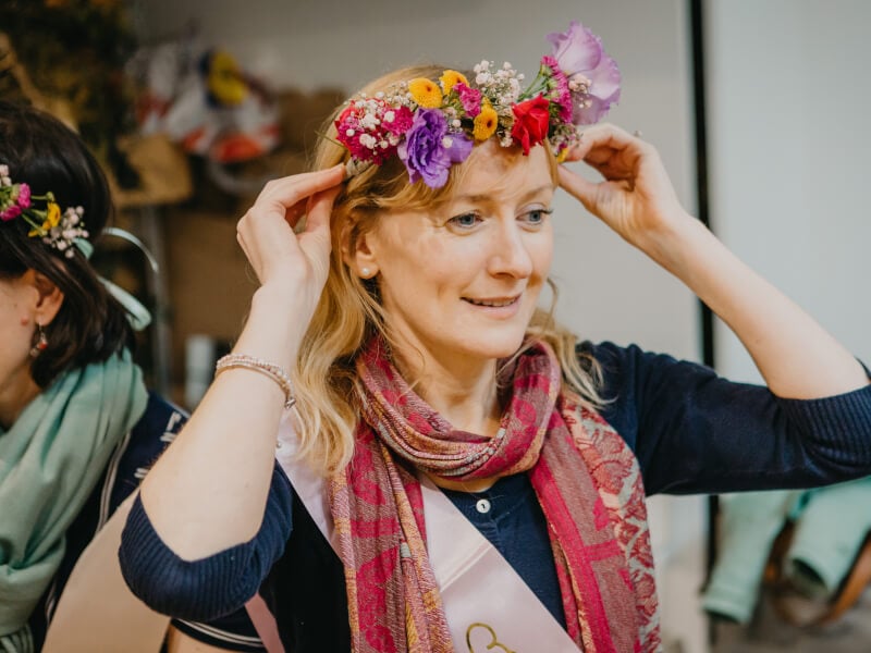 Woman placing handmade flower crown on head