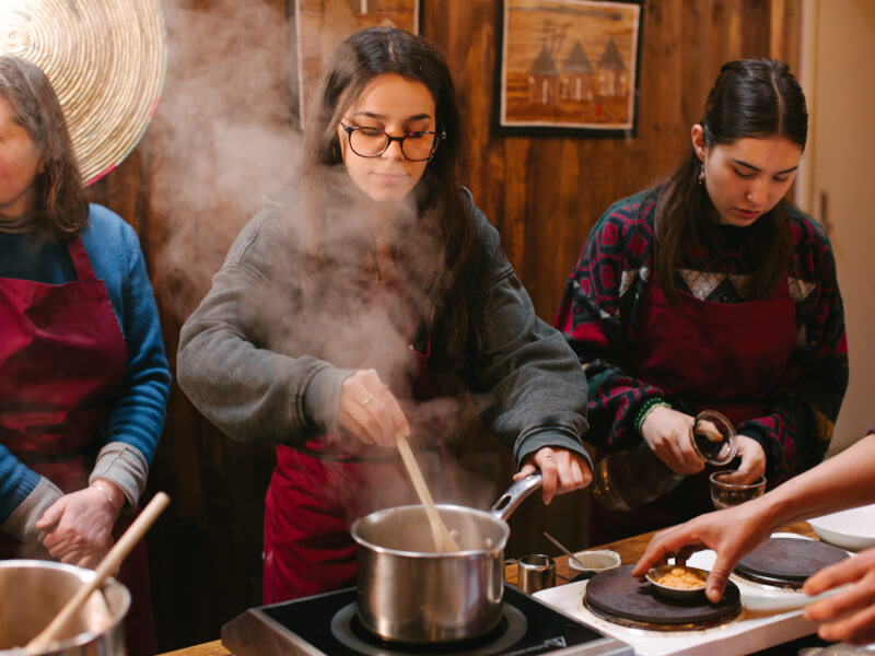 Three women prepare food at a Melbourne cooking class