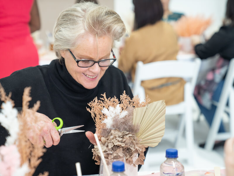 A woman trims plants at a gardening workshop