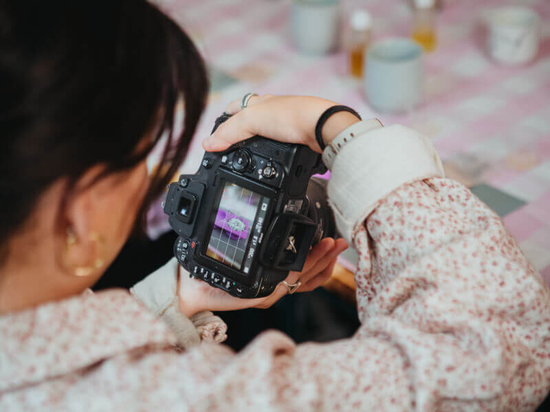 A woman uses a professional camera to take photos at a photography class