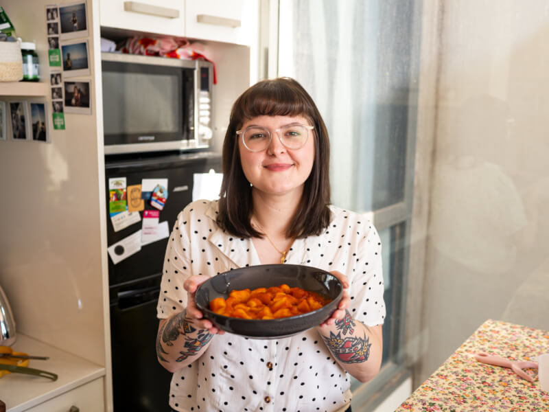 Woman holds bowl of handmade gnocchi at a Melbourne cooking class
