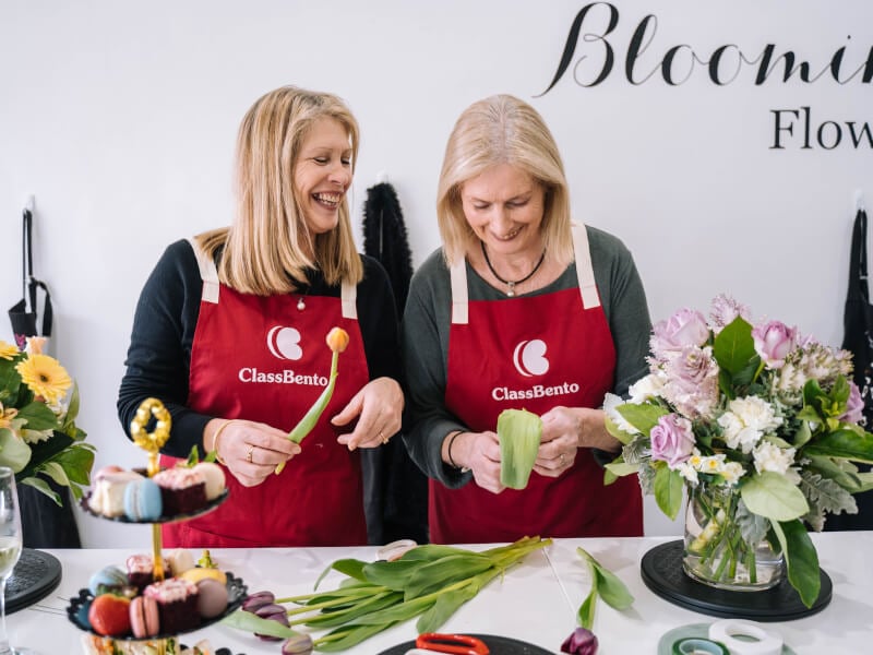 Women arranging flowers together