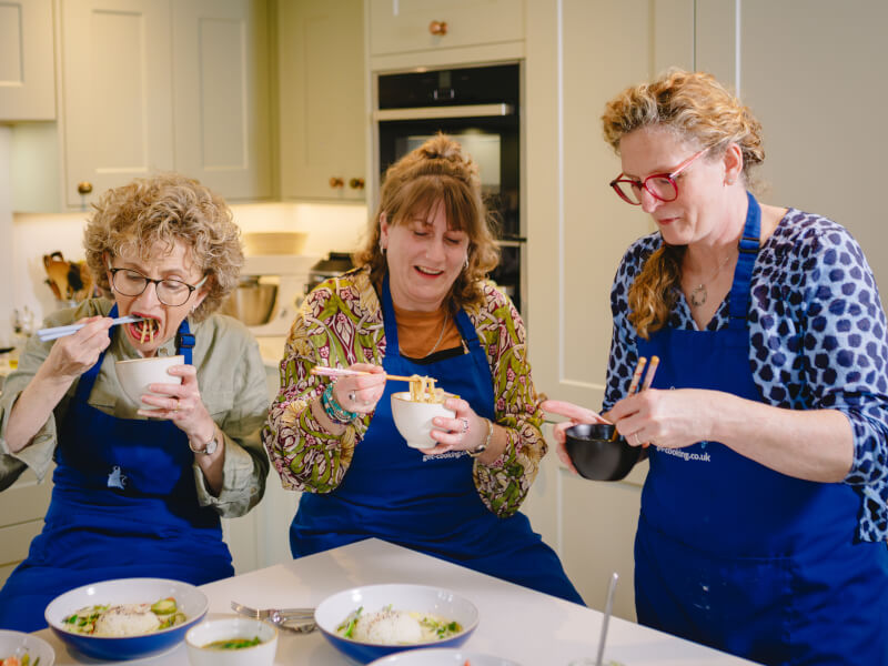 Three friends eating their food at a cooking class