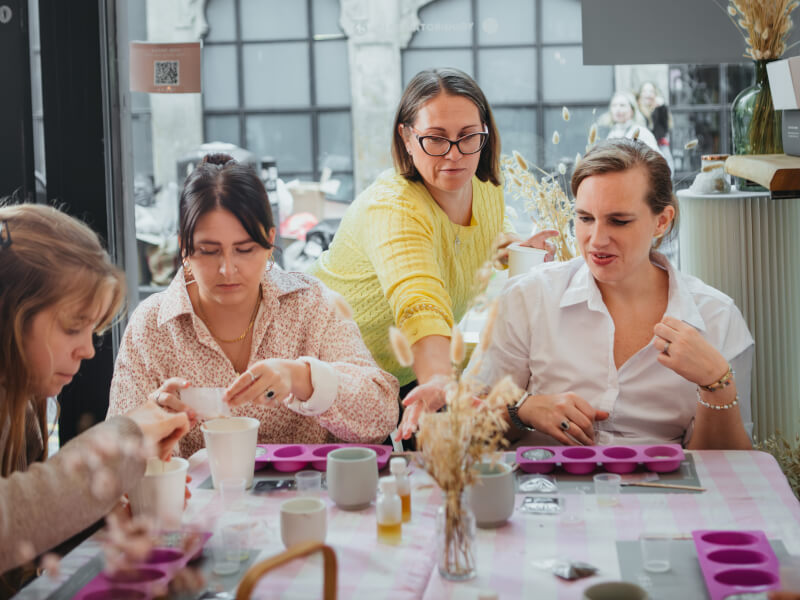 Group of women celebrate a birthday making soap in moulds at a skincare class
