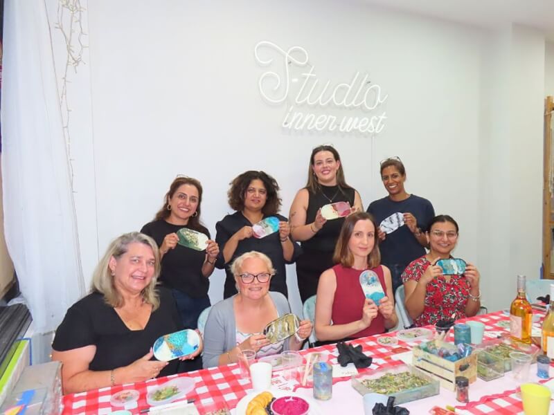 Women gathered and showing their resin trays