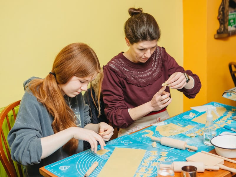 A mother makes pasta with her daughter at cooking class