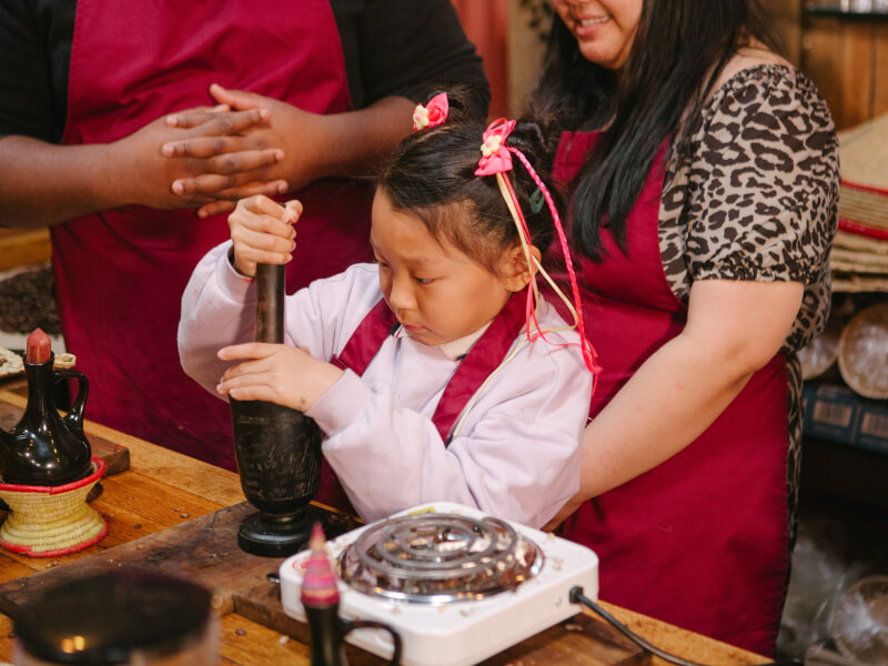 Young girl at a tea and coffee class with her mum